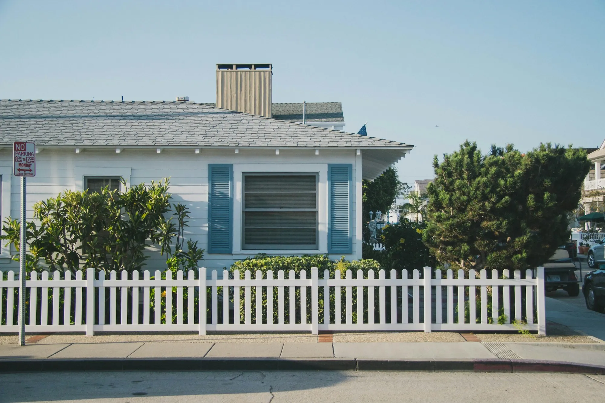 Home behind a white picket fence with a front sidewalk